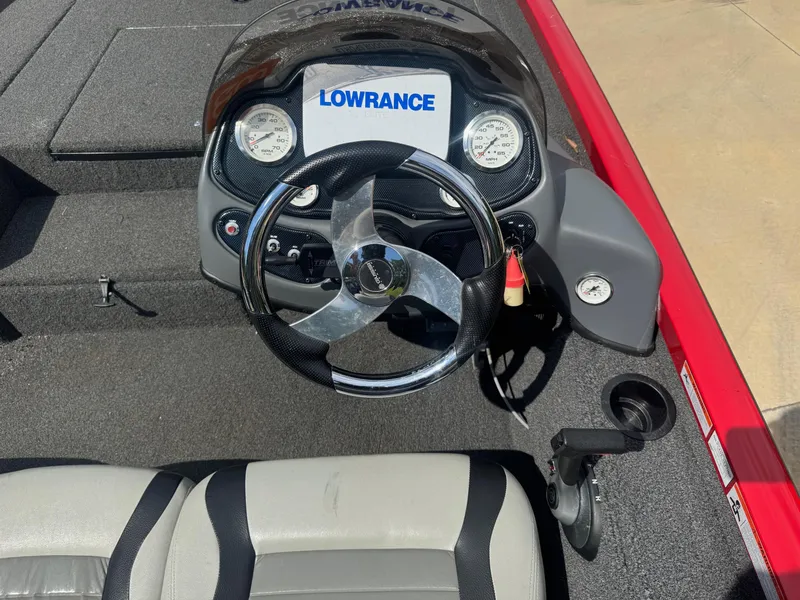 Slide: The Image of 2014 Lowe Stinger 18 HP boat dashboard with steering wheel and gauges. - 4