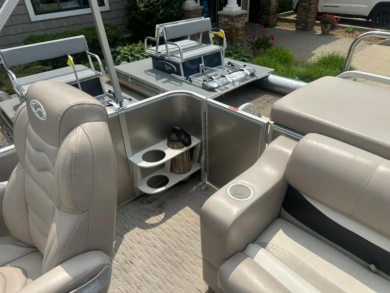 Slide: The Image of 2010 Crest II LM 22 pontoon boat interior with beige seating and cup holders. - 11