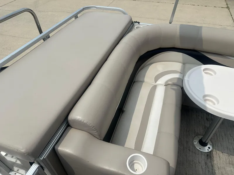 Slide: The Image of 2010 Crest II LM 22 pontoon boat interior with beige seating and round table. - 12