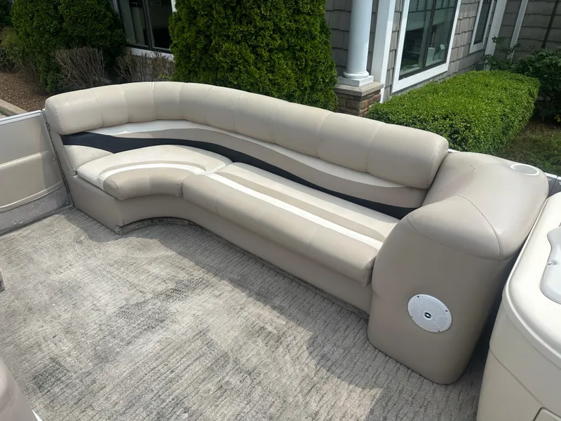Slide: The Image of 2010 Crest II LM 22 pontoon boat seating with beige upholstery and outdoor setting. - 15