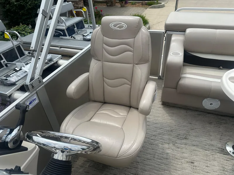 Slide: The Image of Captain's chair on 2010 Crest II LM 22 pontoon boat, featuring beige leather upholstery. - 7