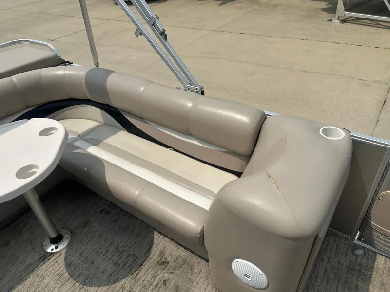 Slide: The Image of 2010 Crest II LM 22 pontoon boat interior with beige seating and table. - 9