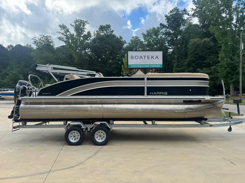 The Image of 2022 Harris Cruiser 230 pontoon boat on trailer, certified pre-owned, outdoor setting. - 0