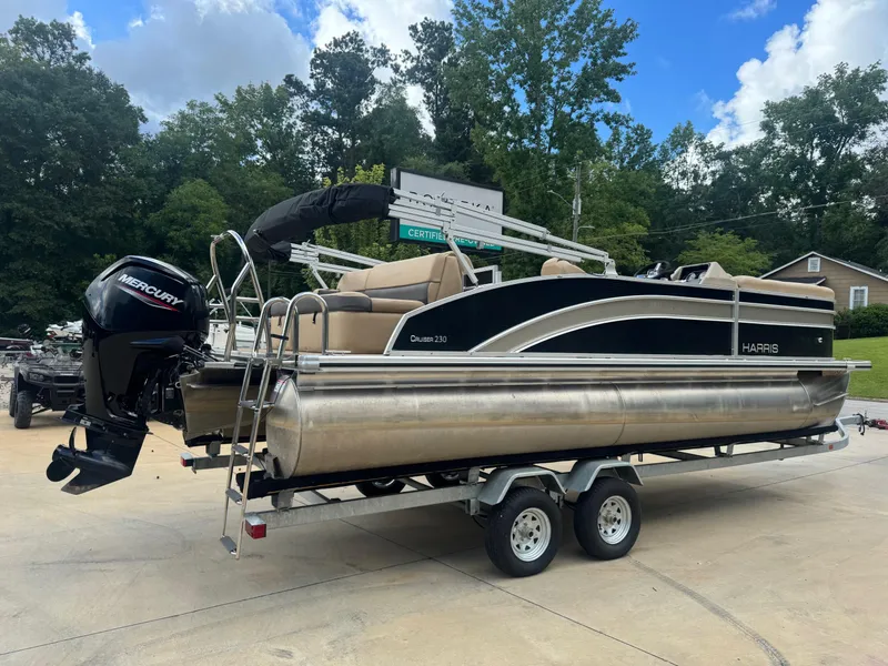 Slide: The Image of 2022 Harris Cruiser 230 pontoon boat on trailer, featuring Mercury outboard motor. - 3