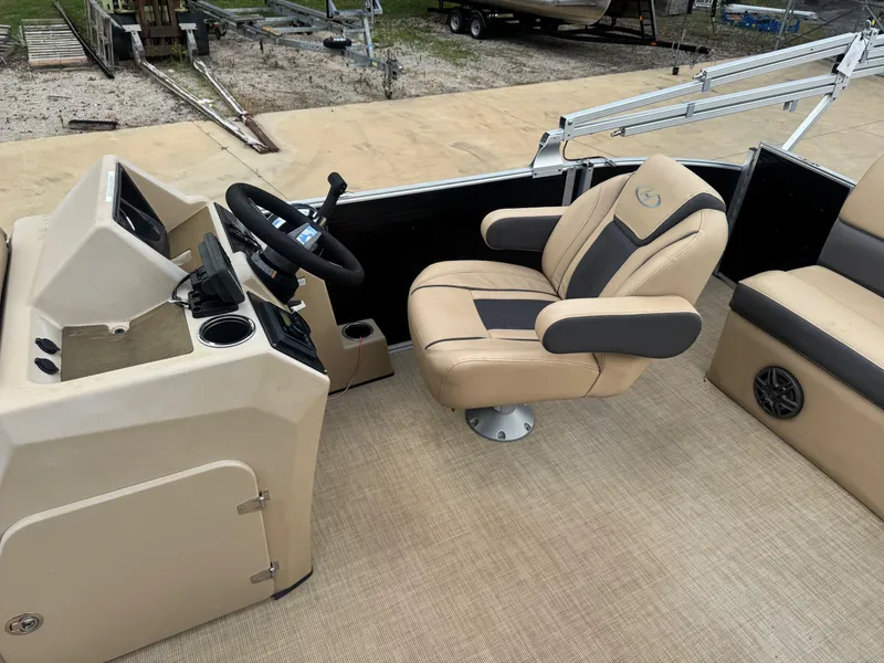 Slide: The Image of 2022 Harris Cruiser 230 boat interior with beige captain's chair and steering console. - 5
