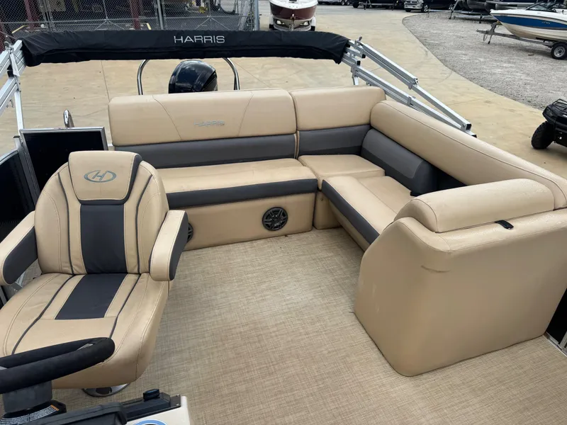 Slide: The Image of 2022 Harris Cruiser 230 boat interior with beige seating and steering chair. - 6