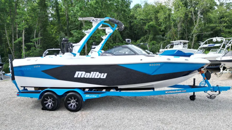 The Image of 2025 Malibu Wakesetter 23 LSV boat in blue and white, parked on a trailer. - 1