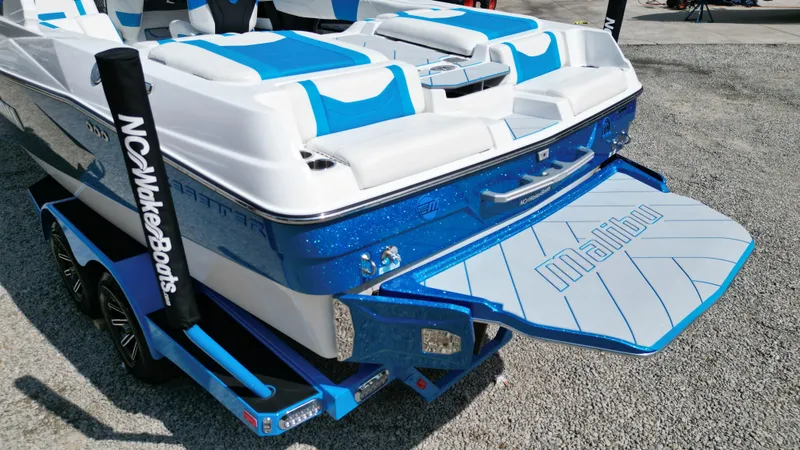 Slide: The Image of 2025 Malibu Wakesetter 23 LSV boat with blue and white design on a trailer. - 13