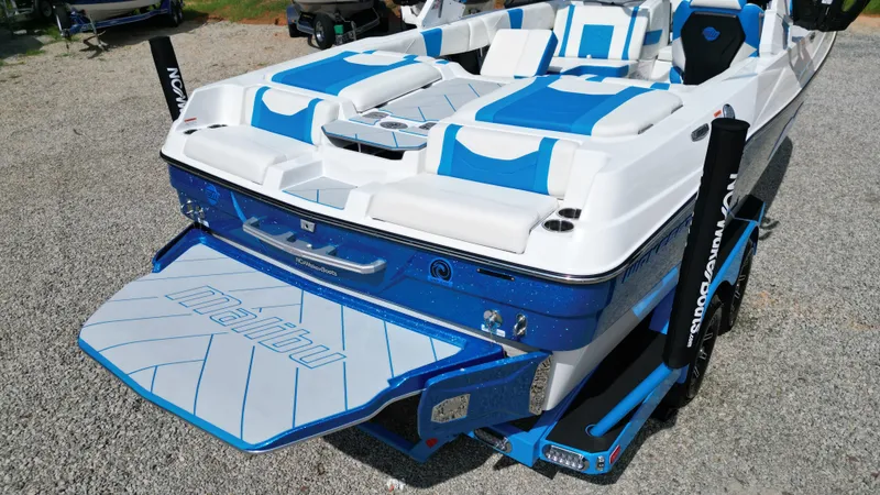 Slide: The Image of 2025 Malibu Wakesetter 23 LSV boat with blue and white seating, rear view. - 14