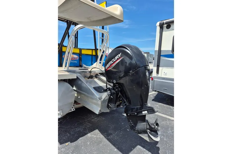 Slide: The Image of 2021 Bahama 240 Tritoon Coral Reef boat with blue canopy and lush background. - 10
