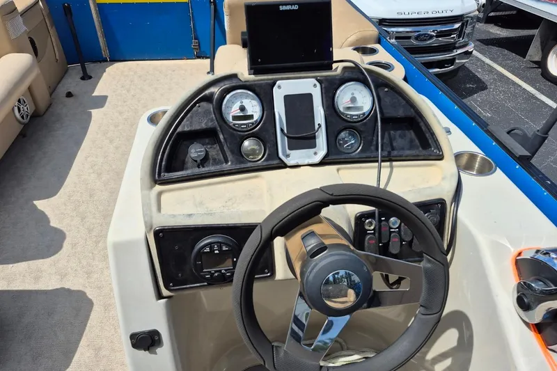 Slide: The Image of 2021 Bahama 240 Tritoon Coral Reef boat interior with beige seating and cup holders. - 15