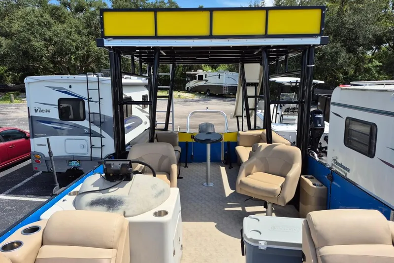 Slide: The Image of 2021 Bahama 240 Tritoon Coral Reef boat interior with steering console and seating. - 20