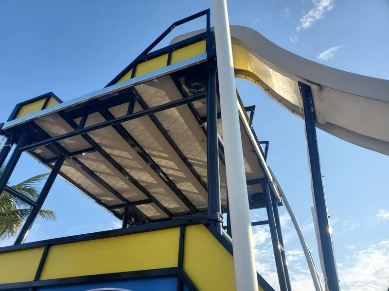 Slide: The Image of 2021 Bahama 240 Tritoon Coral Reef boat interior with seating and table on open water. - 3