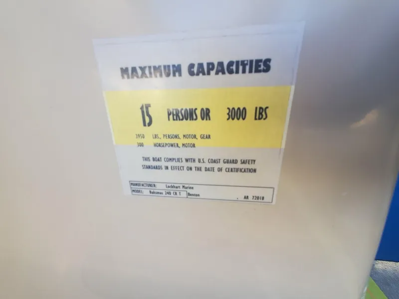 Slide: The Image of Yellow deck of 2021 Bahama 240 Tritoon Coral Reef boat near a house and palm tree. - 7