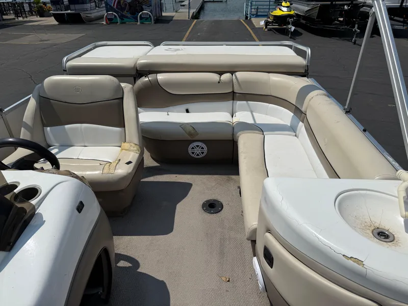 Slide: The Image of 2000 Sun Tracker PARTY BARGE 25 interior with beige seating and steering console. - 12