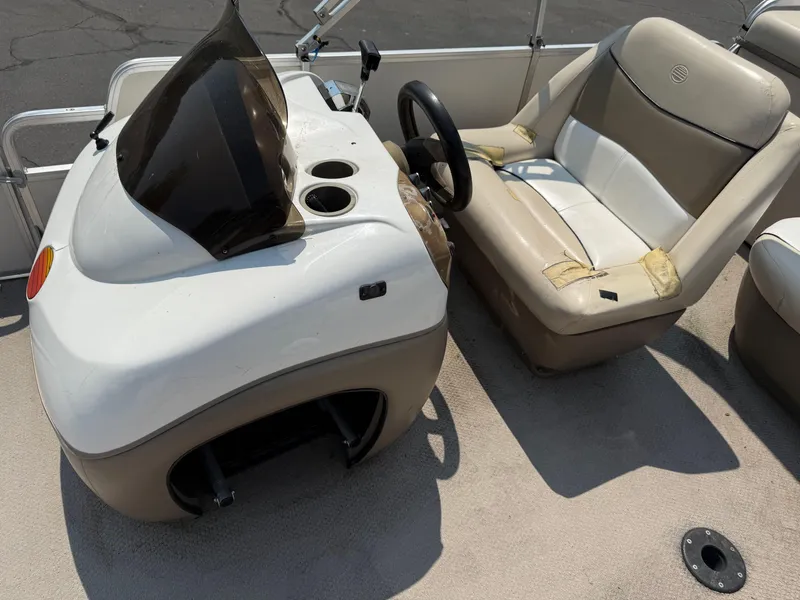 Slide: The Image of 2000 Sun Tracker PARTY BARGE 25 boat interior with steering console and worn seating. - 13