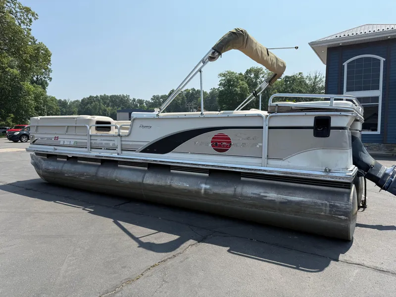 Slide: The Image of 2000 Sun Tracker PARTY BARGE 25 pontoon boat parked outdoors. - 2