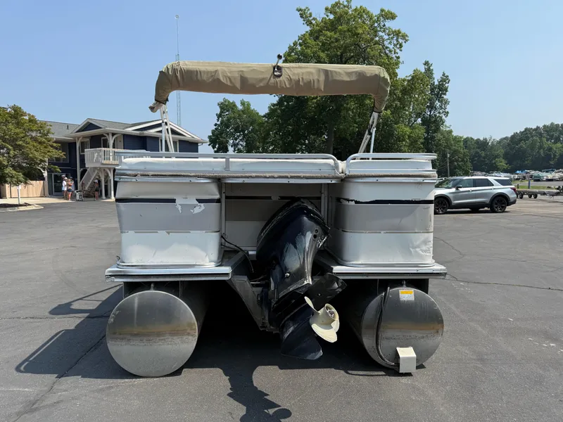 Slide: The Image of 2000 Sun Tracker PARTY BARGE 25 pontoon boat with canopy, parked on asphalt. - 4