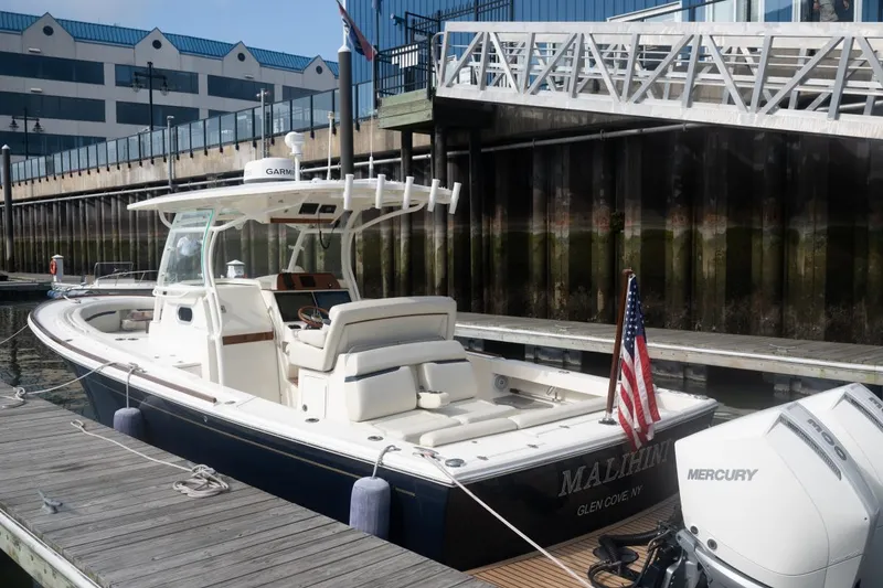 Slide: The Image of 2019 Hunt Yachts 32 Center Console docked, featuring a Mercury engine and American flag. - 16