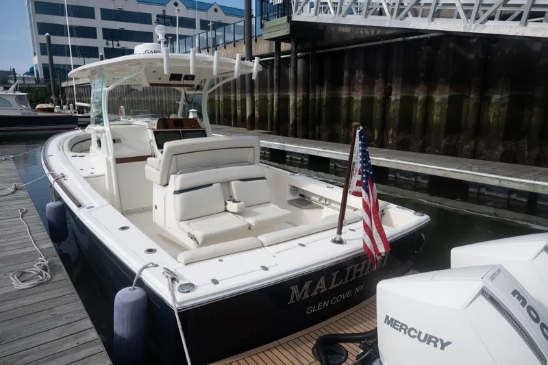 Slide: The Image of 2019 Hunt Yachts 32 Center Console docked, featuring sleek design and American flag. - 17