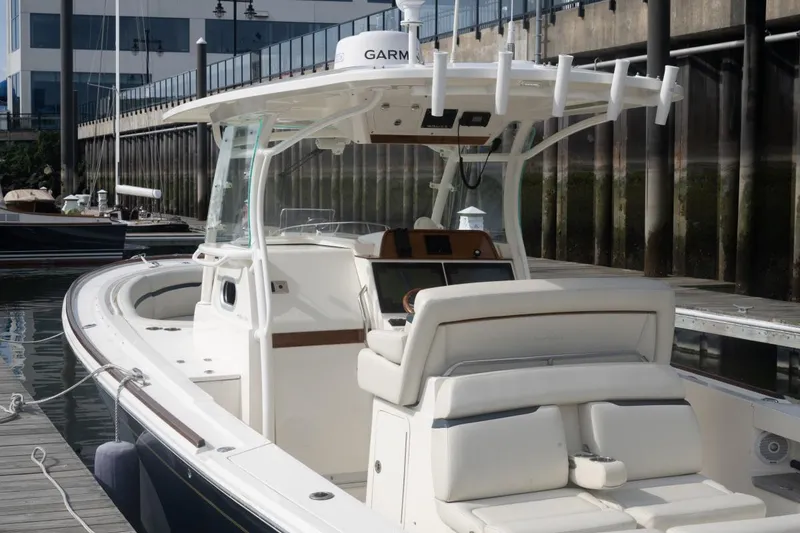 Slide: The Image of 2019 Hunt Yachts 32 Center Console docked, featuring sleek design and modern navigation equipment. - 18