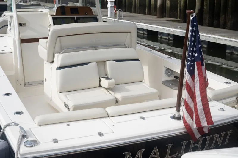 Slide: The Image of 2019 Hunt Yachts 32 Center Console with American flag, docked, featuring luxurious seating. - 21