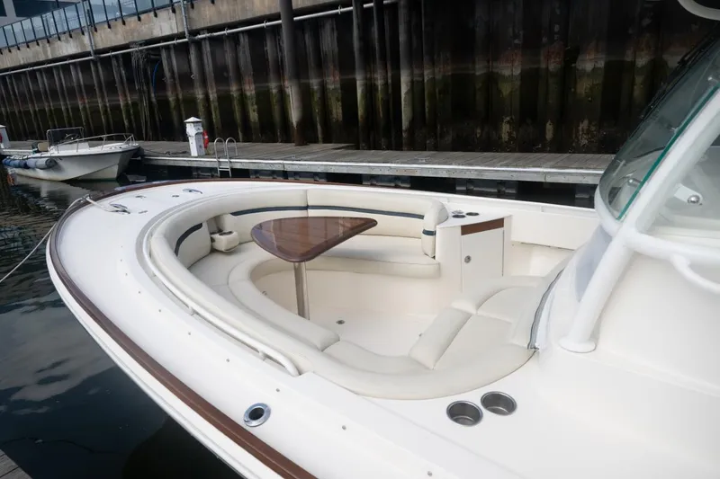Slide: The Image of 2019 Hunt Yachts 32 Center Console with elegant seating and wooden table at dock. - 26