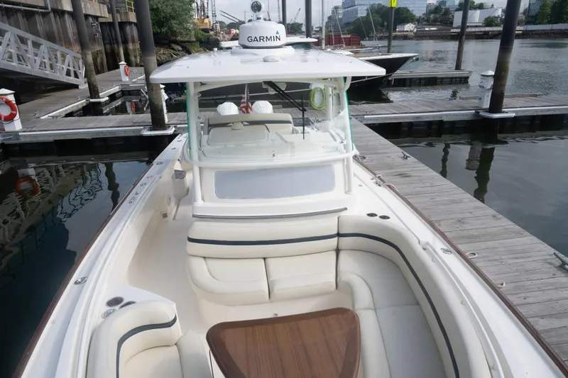 Slide: The Image of 2019 Hunt Yachts 32 Center Console docked, featuring spacious seating and Garmin equipment. - 28