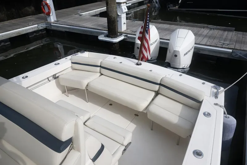 Slide: The Image of 2019 Hunt Yachts 32 Center Console with white seating and twin Mercury engines at dock. - 34