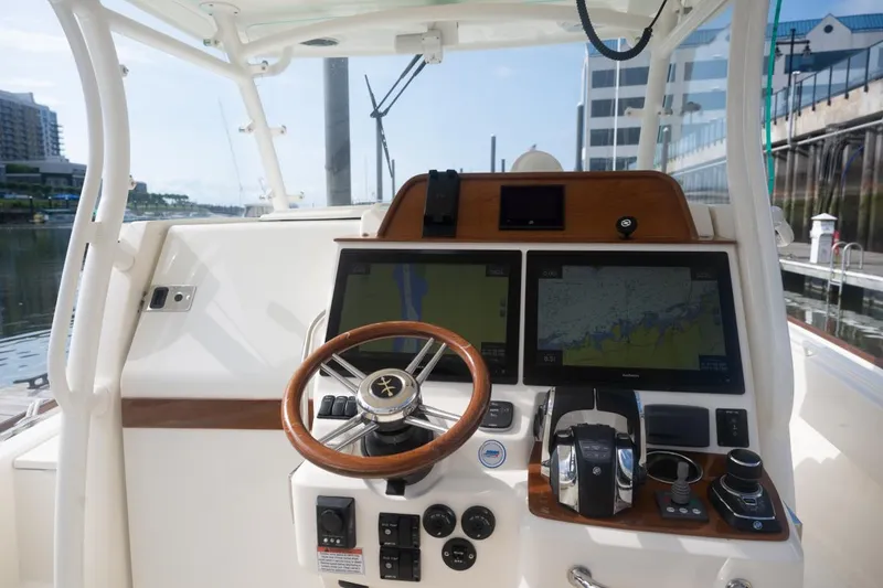 Slide: The Image of 2019 Hunt Yachts 32 Center Console helm with dual navigation screens and steering wheel. - 36