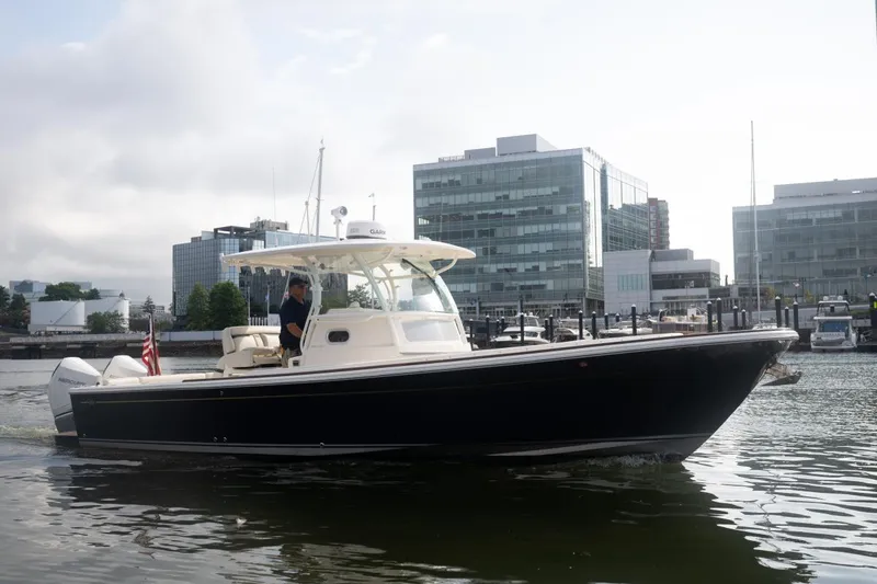 Slide: The Image of 2019 Hunt Yachts 32 Center Console cruising in urban marina setting. - 4