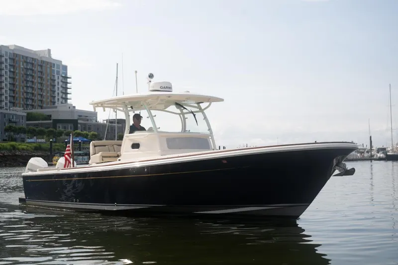 Slide: The Image of 2019 Hunt Yachts 32 Center Console on calm water near urban buildings. - 6