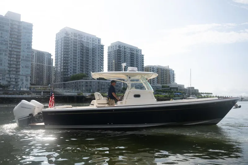 Slide: The Image of 2019 Hunt Yachts 32 Center Console cruising near urban waterfront buildings. - 8
