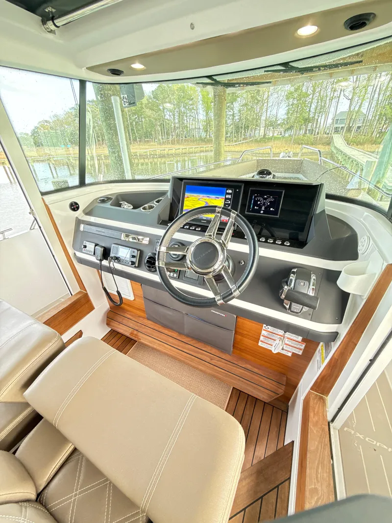 Slide: The Image of Interior of 2019 Axopar 28 CABIN boat with modern dashboard and steering wheel. - 10