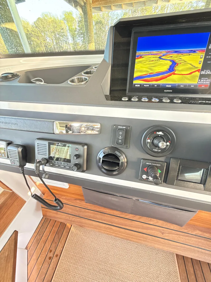Slide: The Image of 2019 Axopar 28 CABIN dashboard with navigation screen and control panel. - 11