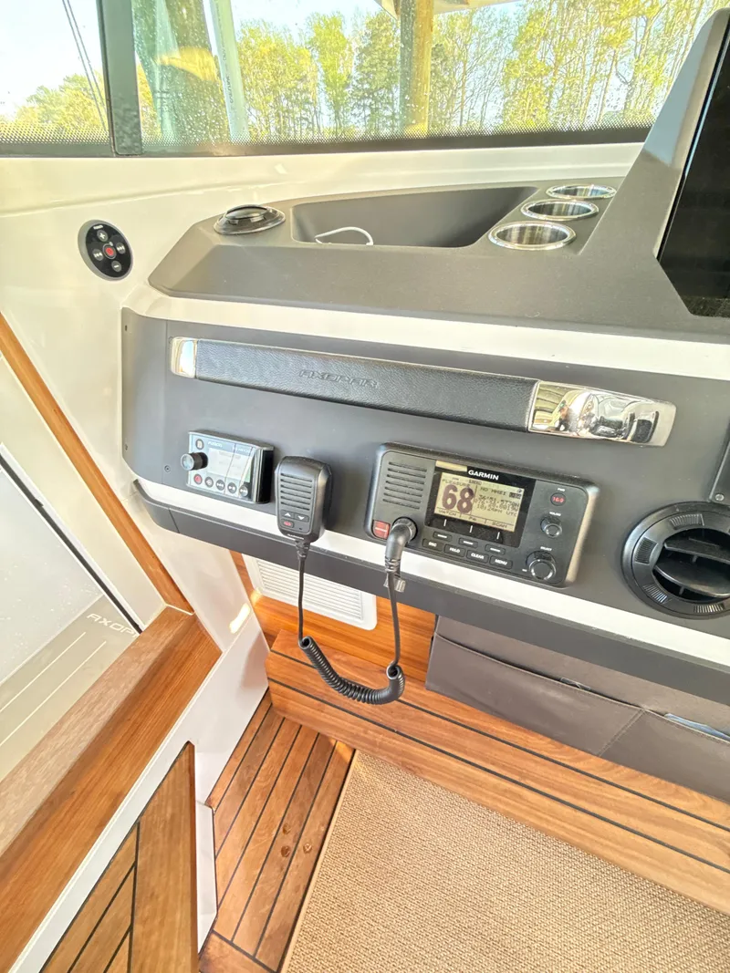 Slide: The Image of 2019 Axopar 28 CABIN interior dashboard with Garmin navigation system and wooden flooring. - 12