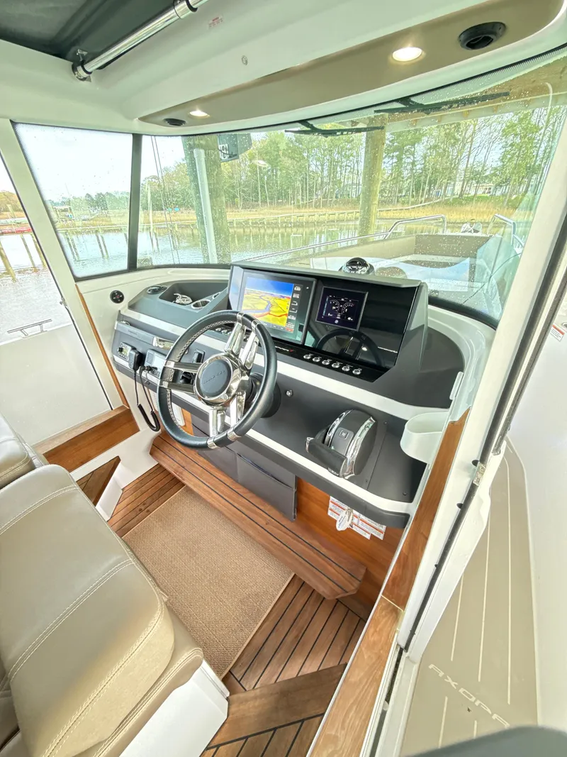 Slide: The Image of Interior of 2019 Axopar 28 CABIN boat with modern dashboard and steering wheel. - 13