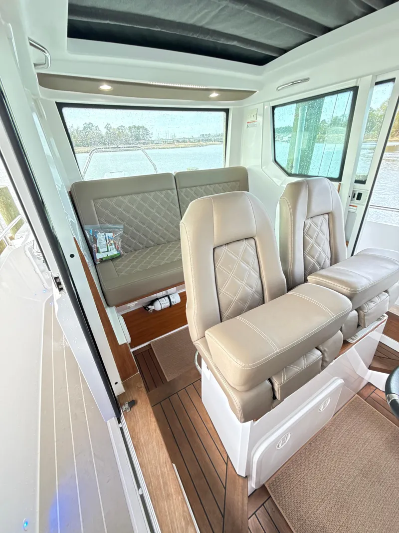 Slide: The Image of Interior of 2019 Axopar 28 CABIN with beige leather seats and wood flooring. - 19