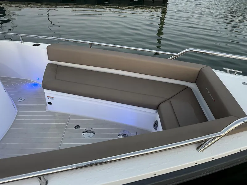 Slide: The Image of 2019 Axopar 28 CABIN boat with cushioned seating, docked on calm water. - 22