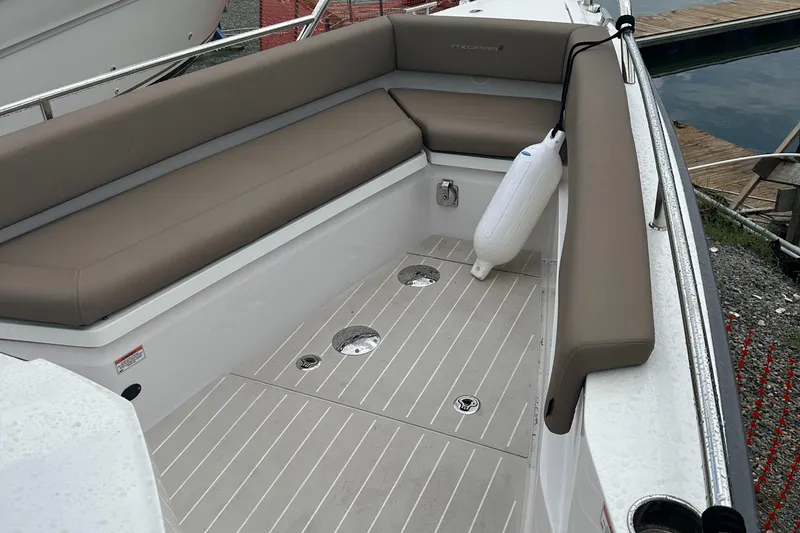 Slide: The Image of 2019 Axopar 28 CABIN boat interior with cushioned seating and deck view. - 23