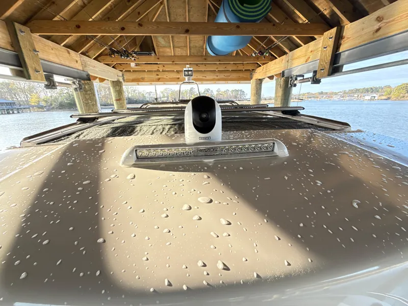 Slide: The Image of 2019 Axopar 28 CABIN boat under wooden shelter with water droplets on the roof. - 27