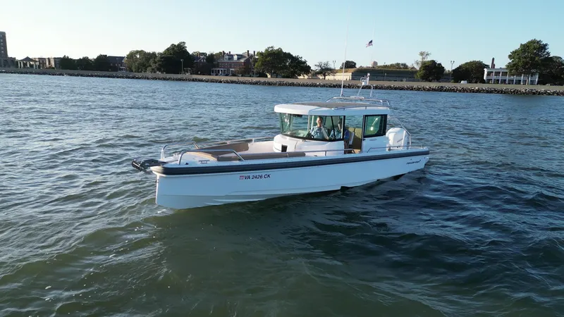 Slide: The Image of 2019 Axopar 28 CABIN boat cruising on a calm river near shoreline. - 3