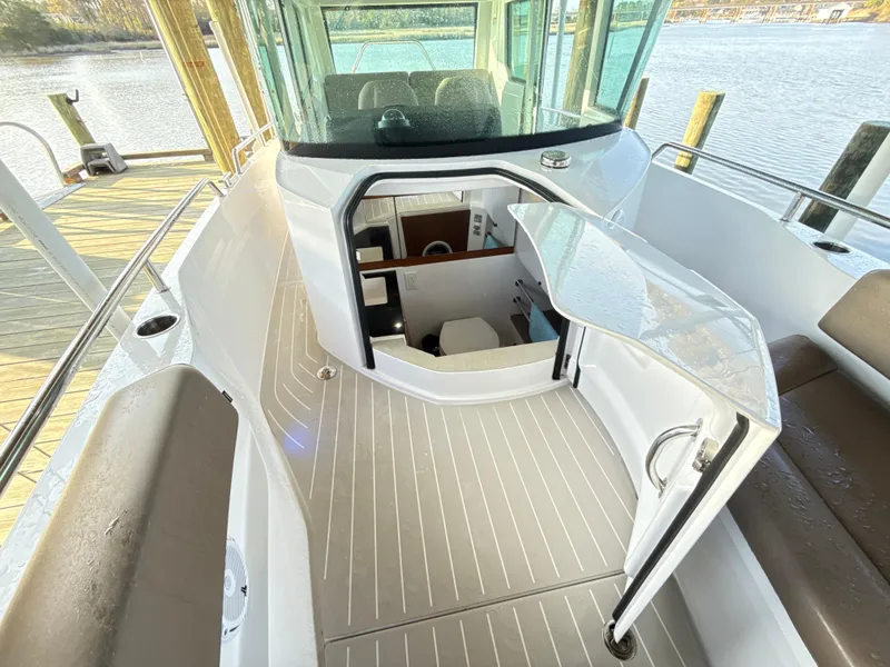 Slide: The Image of 2019 Axopar 28 CABIN boat interior with open cabin door, docked by the water. - 34