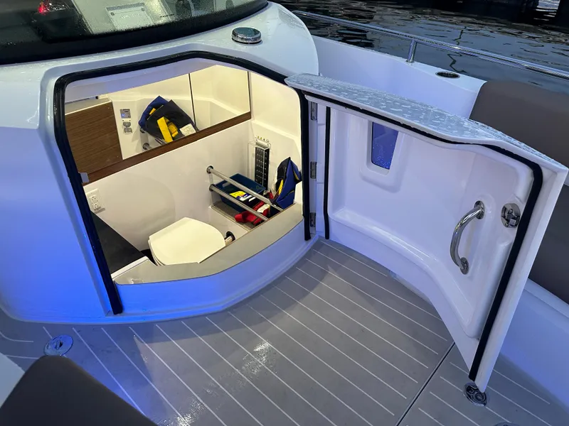 Slide: The Image of 2019 Axopar 28 CABIN interior view with open door, showcasing seating and storage. - 37