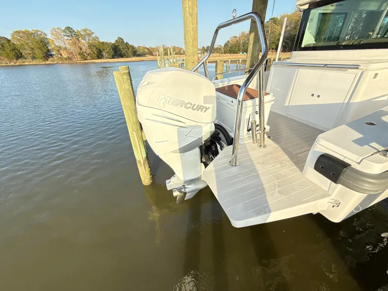 Slide: The Image of 2019 Axopar 28 CABIN with Mercury outboard motor docked on calm water. - 45