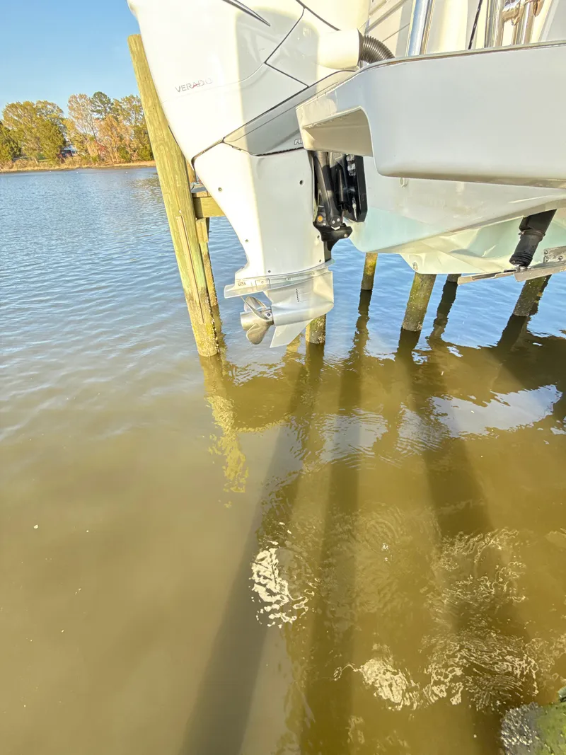 Slide: The Image of 2019 Axopar 28 CABIN boat engine above water near wooden dock. - 46