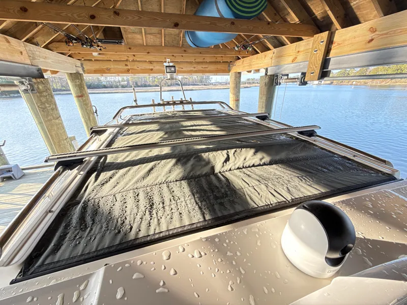 Slide: The Image of 2019 Axopar 28 CABIN boat under wooden dock, with water droplets on the surface. - 49