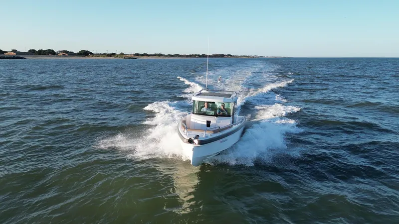 Slide: The Image of 2019 Axopar 28 CABIN boat cruising on open water. - 5