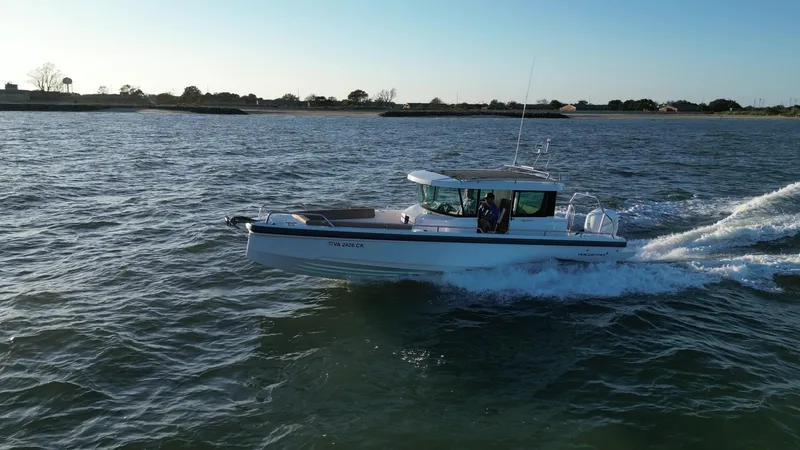 Slide: The Image of 2019 Axopar 28 CABIN boat cruising on open water under clear skies. - 7