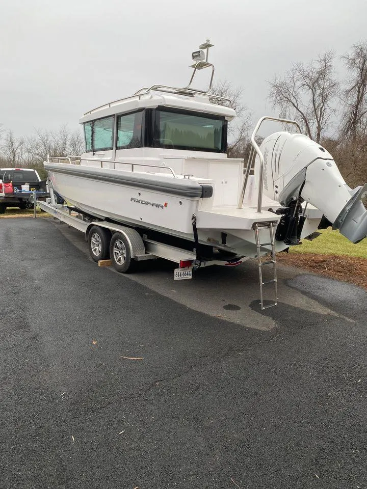 Slide: The Image of 2019 Axopar 28 CABIN boat on trailer, parked outdoors on overcast day. - 9